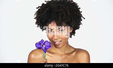 Pretty african american woman holding blue orchid isolated on grey Stock Photo