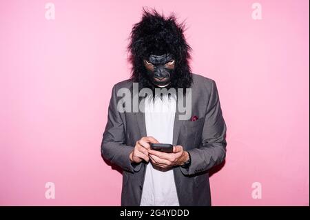 Gesture man with gorilla mask using smart phone Stock Photo