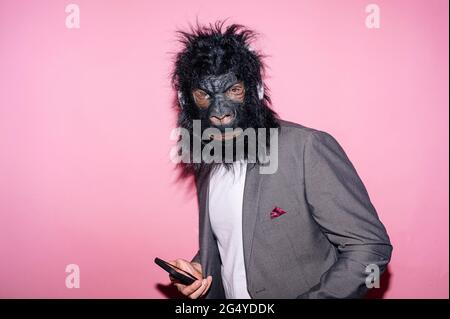 Gesture man with gorilla mask using smart phone Stock Photo