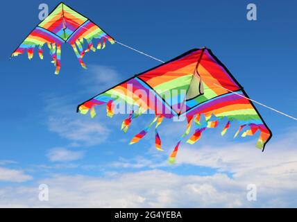 two large colorful kites flying high in the sky with brightly colored Stock Photo