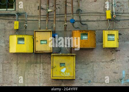 yellow electricity meters on the wall of a residential building close-up Stock Photo