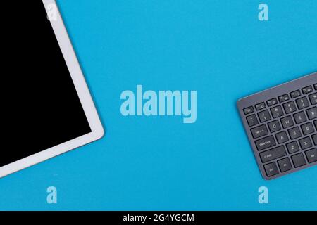 Office Workplace with Digital Gadgets Lying on Blue Table - Flat Lay Stock Photo