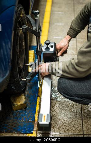 Close-up of a tire clamped by a leveler that passes the automatic alignment of the wheels in the garage, garage and tools for the mechanic. new Stock Photo