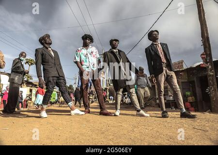 A group of street models match through the streets in Kibera Slums dressed  in their classic
