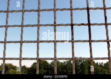 several rows of metal mesh with square cells used as a guard, in the background in the background of the sky Stock Photo