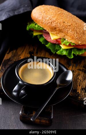 Cup of aromatic coffee and healthy sandwiches with bran bread, cheese, lettuce, tomato and sliced salami and glass of freshly squeezed orange juice on Stock Photo