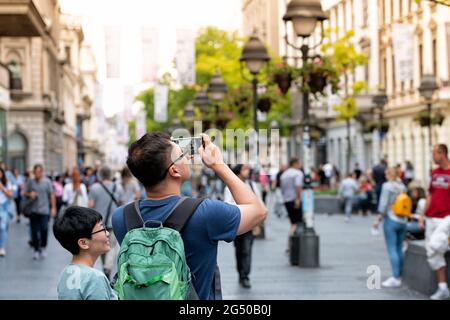 Belgrade, Serbia - September 22, 2019: Asian tourist taking photos with mobile phone on Knez Mihailova Street Stock Photo