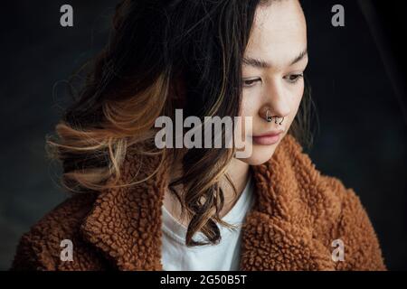 A young contented, trendy woman looking away from the camera. Stock Photo