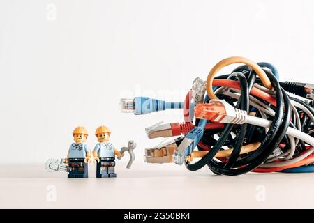 Technicians and a tangled bunch of network cables. Illustrative editorial. Illustrative editorial. June 22, 2021 Stock Photo