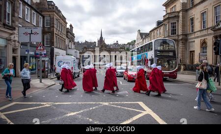 Edinburgh, Scotland, UK. 24 June 2021.  PICTURED: Handmaidens seen walking silently through Edinburgh on the way to the Scottish Parliament.  Credit: Colin Fisher/Alamy Live News. Stock Photo
