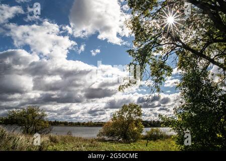 Sun shining through the trees with a view of Moody Lake at Moody Lake Park in Chisago City, Minnesota USA. Stock Photo