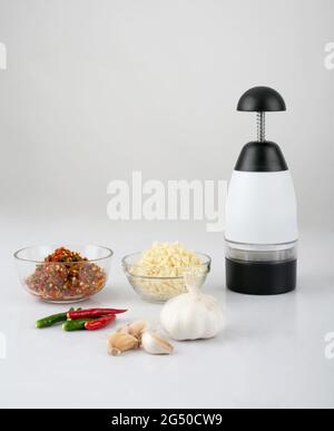 Chopper garlic tool with chopped garlic and chili isolated on white background Stock Photo