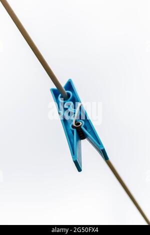 Colored clothes peg hanging by a thread Stock Photo