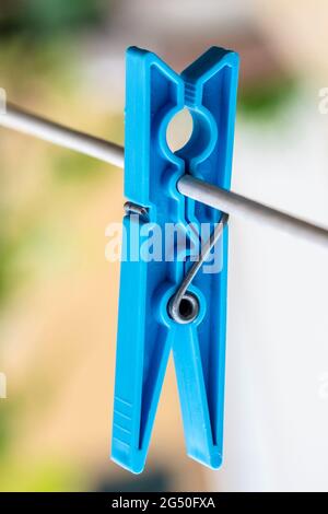 Colored clothes peg hanging by a thread Stock Photo