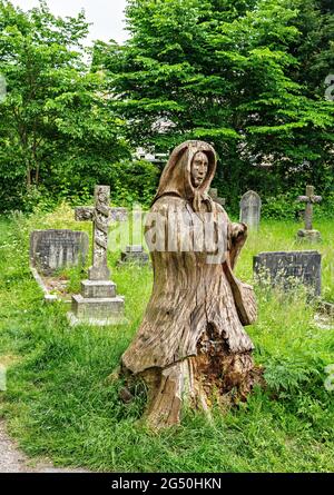 Chainsaw carving of Fisherman's wife (standing opposite her husband)  by Tim Burgess at Holy Trinity churchyard, Morecambe, Lancashire Stock Photo