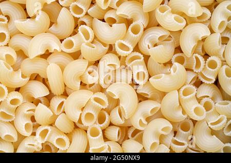 Uncooked pipe rigate macaroni used as a background texture, top view. Stock Photo