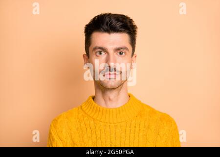 Photo portrait of serious man with mustache wearing bright yellow sweater isolated on pastel beige color background Stock Photo