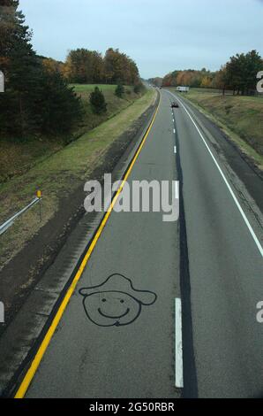 Happy Face with Hat drawn on interstate through Ohio, viewed from pedestrian overpass Stock Photo