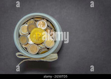 The bitcoin coin lies in the piggy bank on fiat coins. Cryptocurrency accumulation and investment symbol Stock Photo