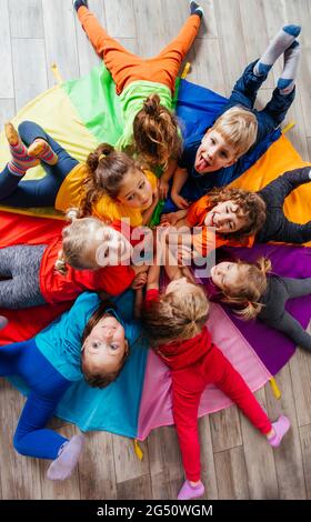 Cheerful children playing team building games on a floor Stock Photo