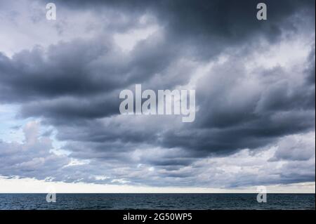 Dark dramatic sky and stormy clouds over tropical sea Stock Photo