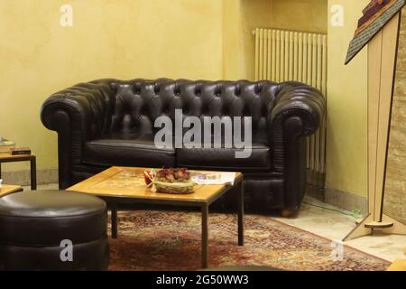 Traditional Chesterfield sofa couch with a small vintage square table Stock Photo