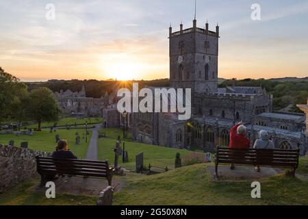 Wales sunset; people watching sunset behind St Davids Cathedral, St Davids, Pembrokeshire Wales UK Stock Photo