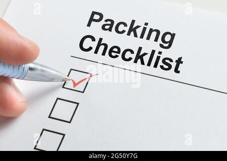 Packing And Travel Checklist. Hand Filling Check List Stock Photo