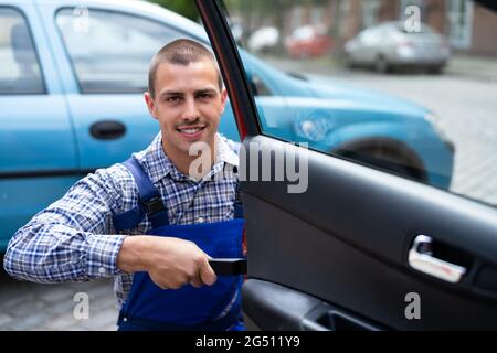 Car Mechanic Removing Door Panel For Repair Service Stock Photo