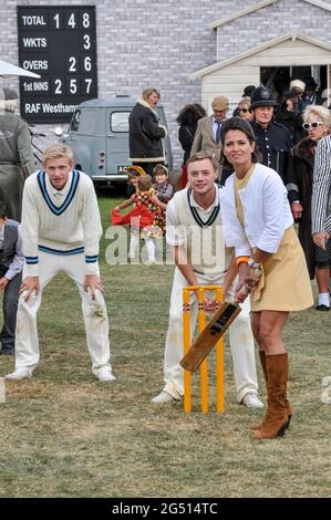 Amanda Stretton, female motorsport and motor industry TV presenter, playing cricket for the cameras at the Goodwood Revival 2012, UK. Presenting Stock Photo