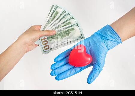 Paid medicine. Patients hand holds out money to the doctor. Costs for the medical insurance. Concept of corruption. Healthcare payment concept Stock Photo