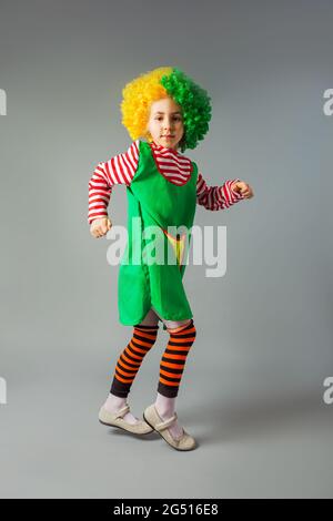 The little girl jumps in a clown uniform Stock Photo