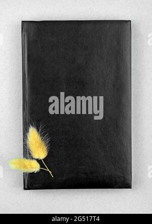 Black leather notebook modern design mockup with dried flowers, copy space, top view Stock Photo