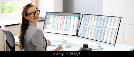 Spreadsheet Analyst Employee Using Computer Monitors For Analysis Stock Photo