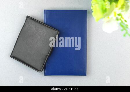 Stylish and fresh workspace composition with black and blue leather notebook on the table with plant, top view, copy space Stock Photo
