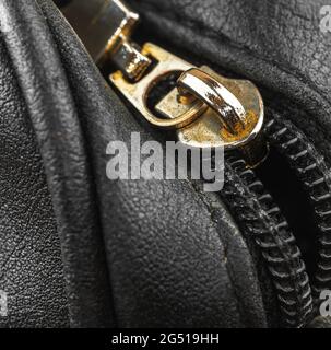 Old metal zipper bag on a leather vintage material, close-up background Stock Photo