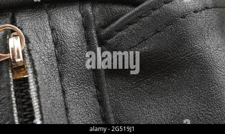 Black leather bag closeup with texture detailed surface, the seams background Stock Photo