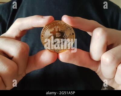 Bitcoin virtual payment coin in hands - closeup Stock Photo