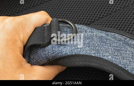 Fabric tapes and slings of the travel backpack close-up in hand, detailed textile Stock Photo