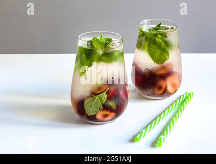 Cold drinks in small bottles. Cherries mint lemonade. Mojito coctail. Stock Photo