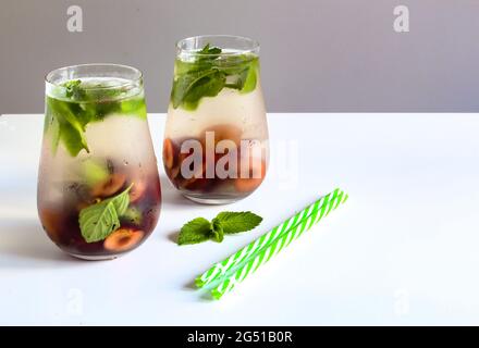Cold drinks in small bottles. Cherries mint lemonade. Mojito coctail. Stock Photo