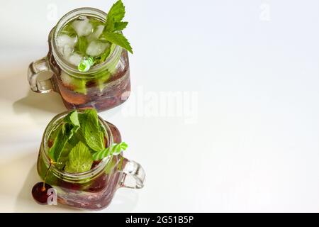 Cold drinks in small bottles. Cherries mint lemonade. Mojito coctail. Stock Photo