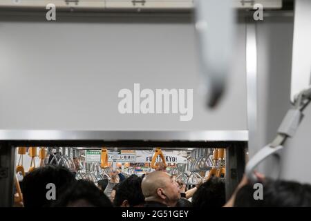 Artistic shot of people holding on to handles on a Tokyp metro train Stock Photo