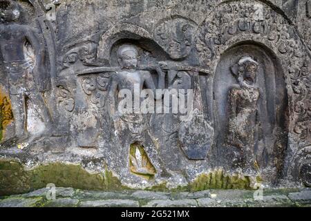 Yeh Pulu - Ancient relief in Desa Bedulu, Kabupaten Gianyar, Bali, Indonesia. Carving in the rock wall. Stock Photo