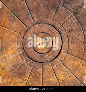 An old rusty cast-iron surface with a relief pattern in the form of lines and circles. Flat layout. Abstract background. Stock Photo