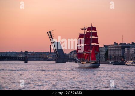 Saint Petersburg, Russia - June 10, 2021: a brig Rossiya sails beside Trinity Bridge on the Neva River at sunrise. Stock Photo