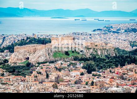 View of the Acropolis of Athens seen from Lycabettus Hill. The Filopappos Hill and the Saronic gulf and Piraeus are in the background. Stock Photo