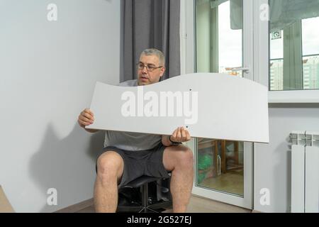a man assembles a new shelf at home. Stock Photo