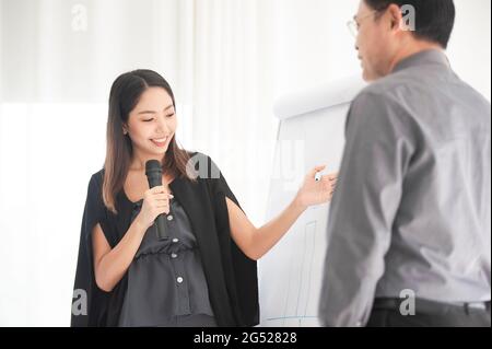 Businesswoman talking microphone present  business plan in meeting room Stock Photo