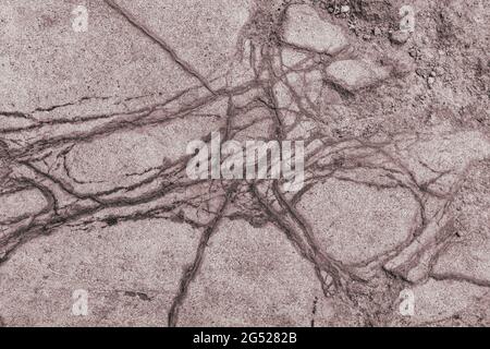 An old gloomy stone wall with deep cracks and uneven textured surfaces. Close-up of grunge concrete base Stock Photo